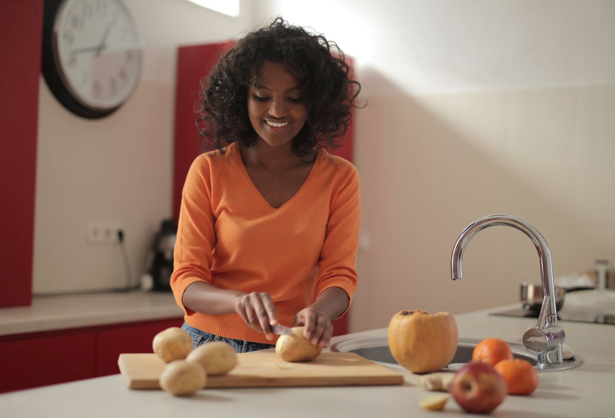 A person preparing fresh vegetables in a kitchen